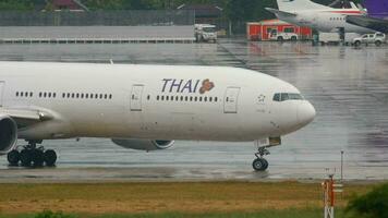 PHUKET, THAILAND DECEMBER 2, 2016 - Thai Airways Boeing 777 HS TKD taxiing before departure from Phuket International airport, rainy weather video