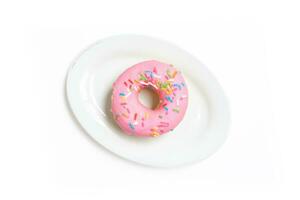 Edited photo. Messy strawberry doughnut on a plate isolated on white background. photo