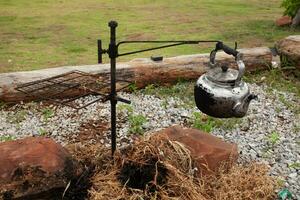 An old and dirty kettle used to boil water in the campsite. photo