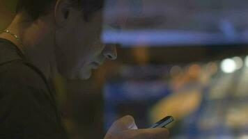 Man behind the glass browsing internet on mobile video