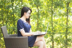 mujer asiática de negocios que trabaja con la computadora portátil en la oficina al aire libre. foto