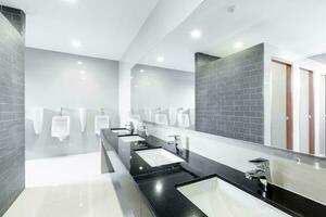 .Interior público del baño con grifo del lavabo del lavabo alineados con un diseño moderno. foto