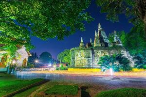 el ligero desde el vela iluminado a noche alrededor el Iglesia de budista en vesak día a wat chet yot Siete pagoda templo eso es un mayor turista atracción en chiang mai, tailandia. foto