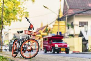 Bicycles parked travel service or Public Area in City for Tourist lot in city moat to busy street with many red taxi and temple of the evening photo