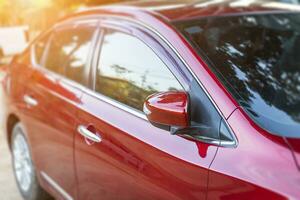 Closeup of window of red car outdoors. photo