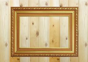 Antique gold fram on wooden wall Empty picture frame on white wooden wall. photo