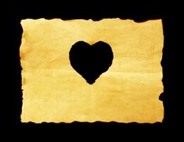 old paper sheet with heart symbol on black background photo