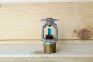 fire sprinkler with fire in wooden background. photo
