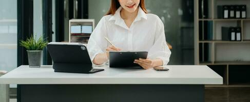 Woman hand using laptop, tablet and smartphone in office. Digital marketing media mobile app and discussing plan new start up project. Finance task. photo