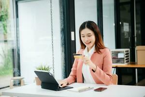 Woman using smart phone for mobile payments online shopping, omni channel, sitting on table, virtual icons graphics interface screen photo