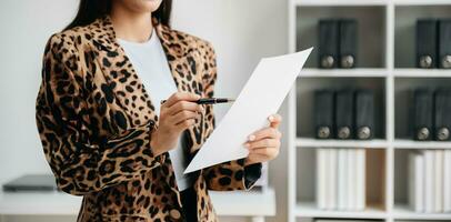 Asian businesswoman working in the office with working notepad, tablet and laptop documents photo