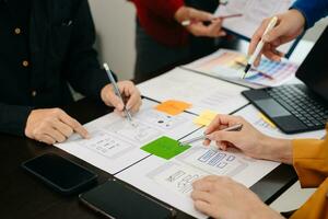 UX developer and ui designer brainstorming about mobile app interface wireframe design with customer breif and color code at modern office. photo