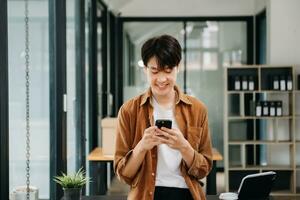 Man using smart phone for mobile payments online shopping, omni channel, sitting on table, virtual icons graphics interface screen photo