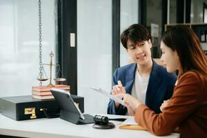 Asian business team and lawyers discussing contract papers sitting at the table. Concepts of law, advice, legal services. at office photo