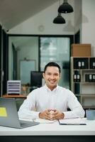 Mature man using laptop and tablet while sitting at her working place. Concentrated at work. photo