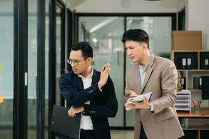 Furious two Asian businesspeople arguing strongly after making a mistake at work in modern office photo