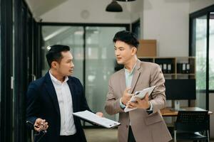 furioso dos asiático gente de negocios discutiendo fuertemente después haciendo un Error a trabajo en moderno oficina foto