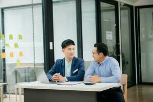 Male discussing new project with business colleague. Young man talking with young man in office. photo