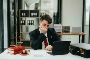 Man lawyer working and gavel, tablet, laptop in front, Advice justice and law concept. photo