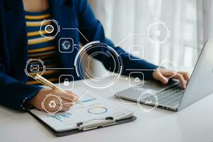 close up of businessman working with laptop computer and smart phone on desk in modern office with virtual icon diagram photo