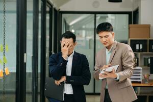 furioso dos asiático gente de negocios discutiendo fuertemente después haciendo un Error a trabajo en moderno oficina foto