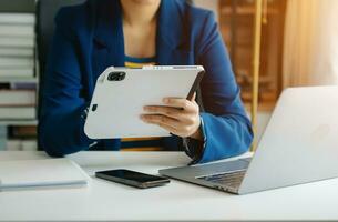 Business woman hand using laptop, tablet and smartphone in office. Digital marketing media mobile app and discussing plan new start up project. photo