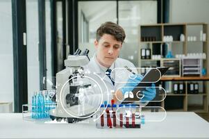 Mature scientists conducting research investigations in a medical laboratory, a researcher in the foreground is using a microscope in laboratory for medicine. photo