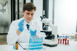 Male biotechnologist testing new chemical substances in a laboratory. photo