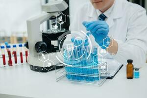 Mature scientists conducting research investigations in a medical laboratory, a researcher in the foreground is using a microscope in laboratory for medicine. photo