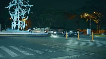 G-walk, Citraland, Surabaya, Indonesia, June 23 2023 - Vehicle traffic at the corner of a T-junction at night. video