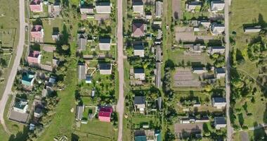 panoramisch antenne visie van eco dorp met houten huizen, grind weg, tuinen en boomgaarden video