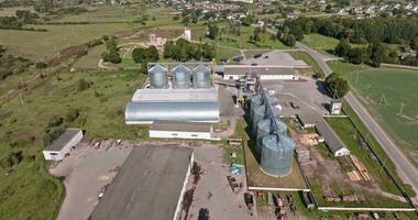 antenne panoramisch visie Aan agro-industrieel complex met silo's en graan drogen lijn voor drogen schoonmaak en opslagruimte van ontbijtgranen gewassen video