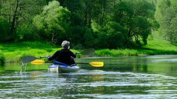 Family kayak trip for seigneur and senora. An elderly married couple rowing a boat on the river, a water hike, a summer adventure. Age-related sports, mental youth and health, tourism, active old age video