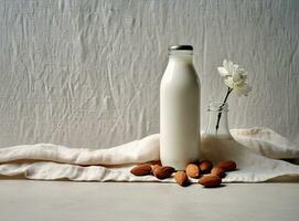 Organic almond milk in glass bottle near ceramic bowl with raw almonds on stone table in the kitchen ready for cooking. Created with Generative AI technology. photo