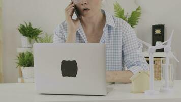 une souriant femme dans des lunettes est travail sur sa portable video