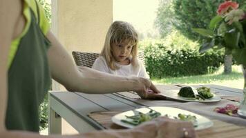 caucasiano menina do 7 anos velho tem brócolis Como uma almoço. video