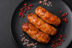 Delicious juicy grilled sausages with salt, spices and herbs photo