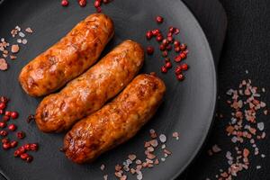 Delicious juicy grilled sausages with salt, spices and herbs photo