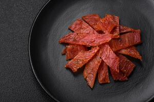 Delicious dried veal or turkey jerky with salt, spices and herbs photo