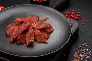 Delicious dried veal or turkey jerky with salt, spices and herbs photo