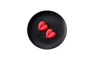 deliciosos dulces de chocolate en forma de corazón sobre un fondo de hormigón oscuro foto