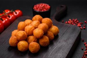 Delicious fried potato balls with breaded mozzarella, salt, spices and herbs photo