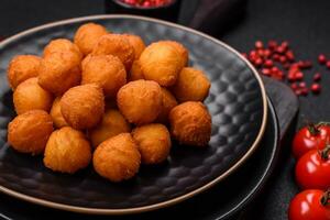 Delicious fried potato balls with breaded mozzarella, salt, spices and herbs photo