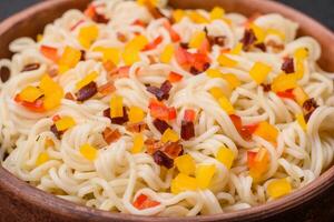 Delicious fresh Asian noodles with pieces of vegetables, meat, with salt, spices and herbs photo