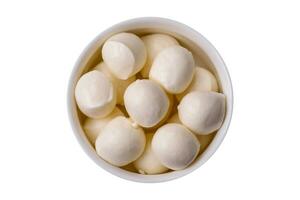 Delicious fresh mozzarella cheese in the form of small balls with salt and spices photo