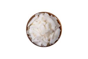 White dry coconut flakes in a wooden bowl prepared for making desserts photo