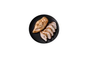 Delicious fresh grilled chicken fillet with salt, spices and herbs on a ceramic plate photo