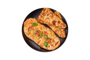 Delicious oven fresh flatbread pizza with cheese, tomatoes, sausage, salt and spices photo