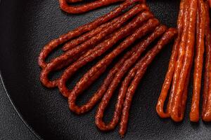 Delicious thin smoked hunting sausages with salt, spices and herbs photo