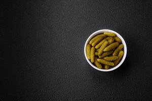 Delicious small pickled cucumbers gherkins with onions, mustard, salt and spices photo